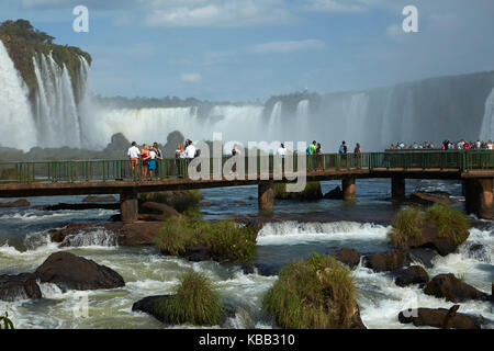 Tourists on viewing platform on Brazil side of Iguazu Falls, Brazil - Argentina border, South America Stock Photo