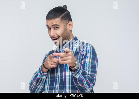Hey you!You cool man! Bearded man, pointing finger and looking at camera. On gray background. Indoor, studio shot Stock Photo