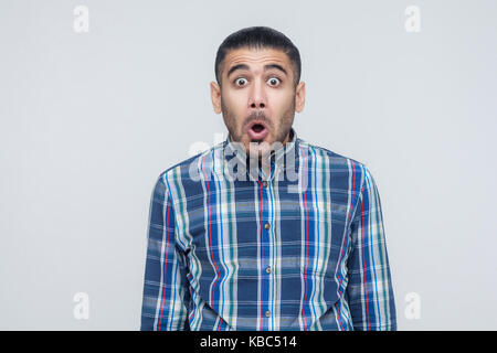 Man opened mouth and scream. Have a shocked face and big eyes. Studio shot Stock Photo