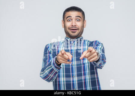 I need this! Happiness man pointing fingers at camera and have a joyful look. Studio shot Stock Photo