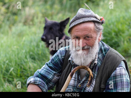 Shepherd and flock of sheep in nature green. portrait in black and white. Trentino Alto Adige - northern Italy Stock Photo