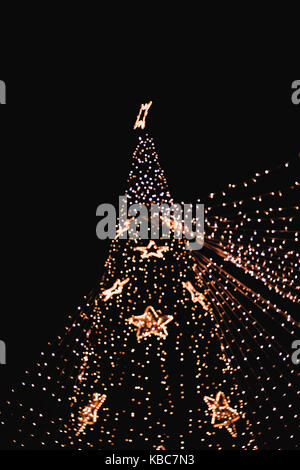 Low Angle View Of Slightly Defocused Lights On Christmas Tree During Night Stock Photo