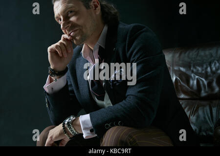 Businessman sitting on an armchair Stock Photo