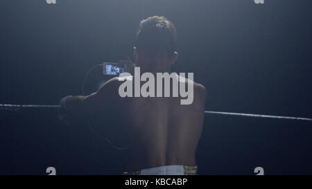 Boxer looks in the phone. Rear view of a boxer who looks match his rival on the phone Stock Photo