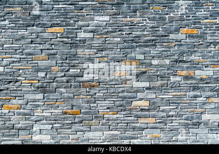 stone wall texture background with grey and orange stones Stock Photo
