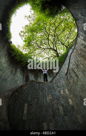 woman hands up at underground crossing in tunnel at Fort Canning Park, Singapore Stock Photo