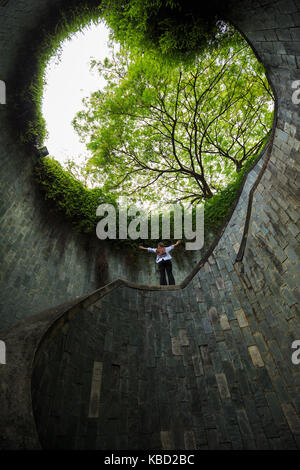 woman hands up at underground crossing in tunnel at Fort Canning Park, Singapore Stock Photo