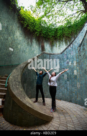 woman and man hands up at underground crossing in tunnel at Fort Canning Park, Singapore Stock Photo