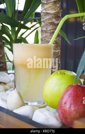 glass of apple juice and green apples on white stone background Stock Photo