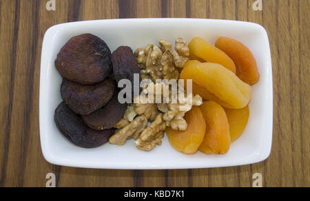 apricot and walnut plate on wooden table Stock Photo