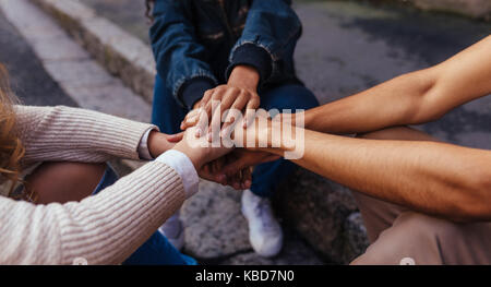 Unity and teamwork. Closeup image of young students making a stack of hands. Stock Photo