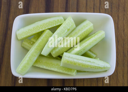 heap of fresh sliced cucumbers on an old wooden table Stock Photo
