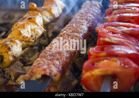 cooking adana kebabs on the restaurant style grill smoke coming out from them that they might be Stock Photo