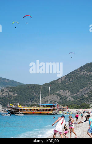 Families and para-gliders on Olu Deniz Belcekiz Beach, Turkey Stock Photo