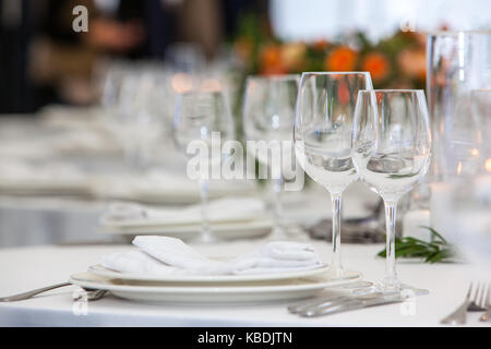 Table setting with glasses for different drinks on table on room background Stock Photo