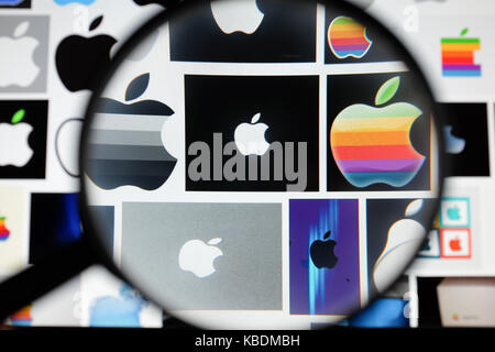 A magnifying glass over Apple logos. Stock Photo
