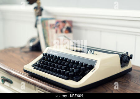 Vintage typewriter and books on the table at home. Stock Photo