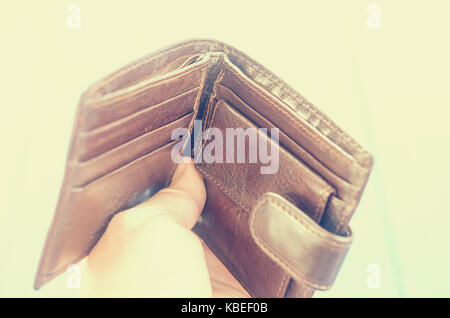 Empty open brown purse in one hand Stock Photo - Alamy