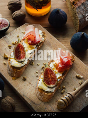 rustic figs bruschetta with honey on wooden table Stock Photo