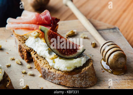 rustic figs bruschetta with honey on wooden table Stock Photo