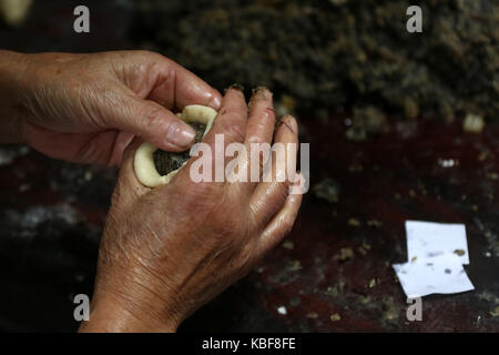Huangshan, China's Anhui Province. 29th Sep, 2017. Cheng Guisheng, a bakery owner, makes mooncakes in Xiuning County of Huangshan, east China's Anhui Province, Sept. 29, 2017. The 68-year-old Cheng Guisheng has learned making a kind of special mooncakes with traditional Anhui characteristics when he was young. The stuffing of the mooncakes is mixed pickled edible wild herbs with lard oil and sugar. This kind of mooncakes are traditional cakes for people in the ancient Huizhou area when Mid-autumn Festival is coming around. Credit: Shi Yalei/Xinhua/Alamy Live News Stock Photo