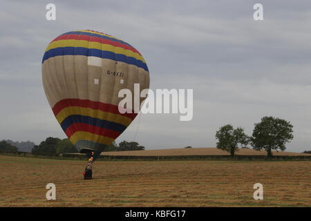 Hot Air Balloon from the York Balloon 2017 Fiesta lands in farmers field near Brandsby, North Yorkshire, England. 50 Balloons will be flying this weekend in York and over the surrounding countryside at the 2017 Fiesta. Stock Photo