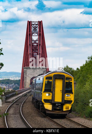 View of Scotrail passenger train approaching Dalmeny Station after crossing Forth Railway Bridge in Lothian , Scotland, United Kingdom. Stock Photo