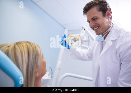 Low angle view of dentist adjusting lamp while looking at patient in medical clinic Stock Photo