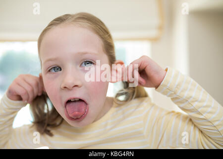 Young girl making funny faces at home Stock Photo