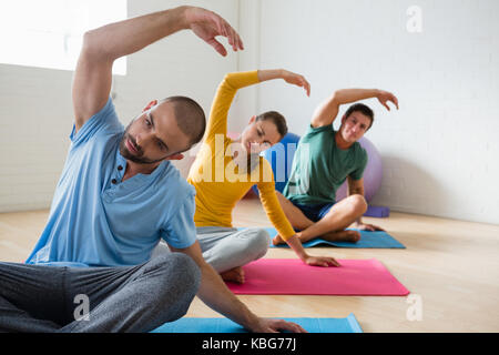 Yoga instructor with students exercising at health club Stock Photo