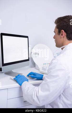 Side view of dentist working on computer at medical clinic Stock Photo