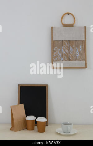 Coffee, parcel, slate and bag against white wall Stock Photo