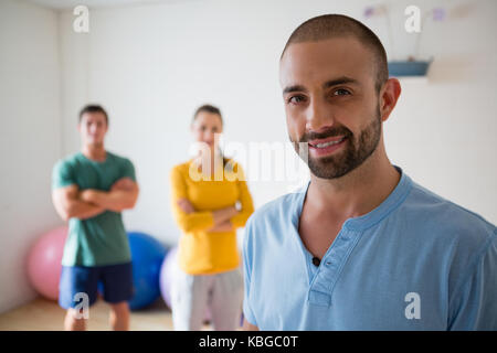 Portrait of confident yoga instructor with student in health club Stock Photo
