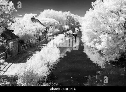 A narrowboat on the Kennet and Avon Canal in Wiltshire shot in infrared. Stock Photo
