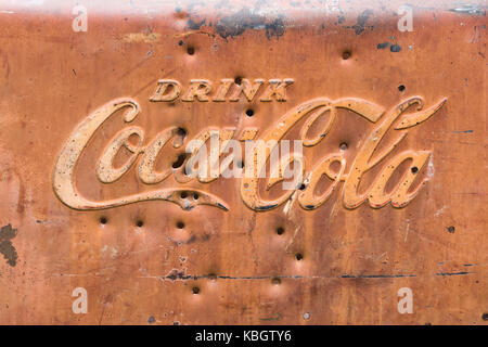 Old rusted coca cola sign with bullet holes. UK Stock Photo