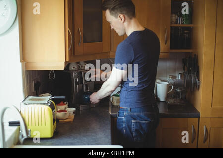 Man making coffee from espresso machine in kitchen Stock Photo