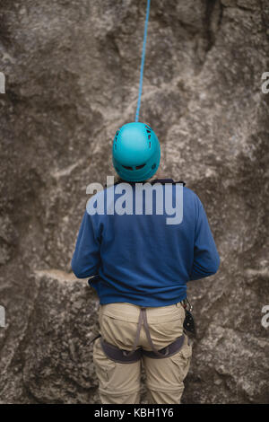 Rear view of man preparing for rock climbing Stock Photo