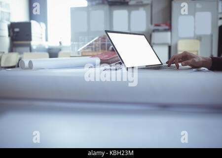 Architect using laptop at table in studio Stock Photo