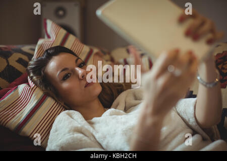 Woman using digital tablet on bed at home Stock Photo