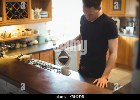 Man making coffee in kitchen at home Stock Photo