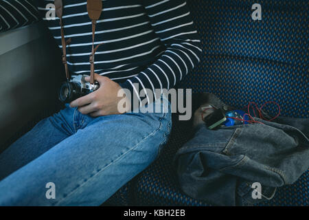 Mid section of man holding digital camera while travelling in metro Stock Photo