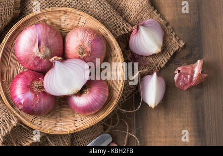 sliced red onions in bamboo basket and on wood background, vegetable for cooking food Stock Photo