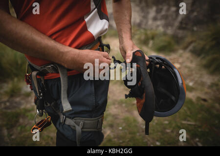 Mid section of man preparing for rock climbing Stock Photo