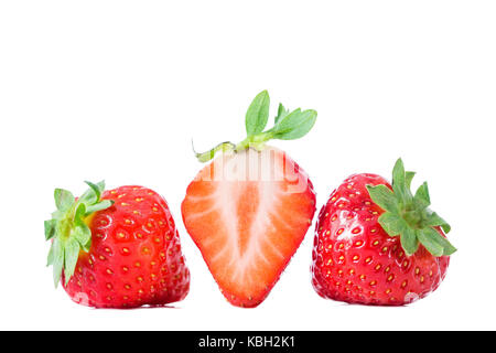 Isolated strawberries. Three strawberry fruits, one cut in half with flower isolated on white background Stock Photo