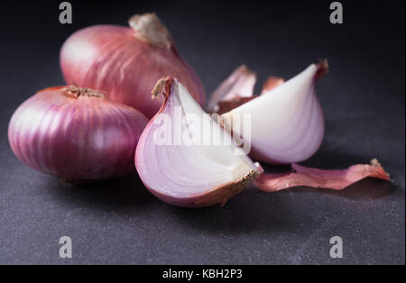 sliced red onions on black stone background, vegetable for cooking food Stock Photo