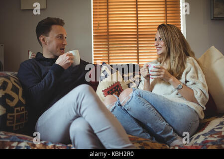 Couple having coffee together on sofa at home Stock Photo