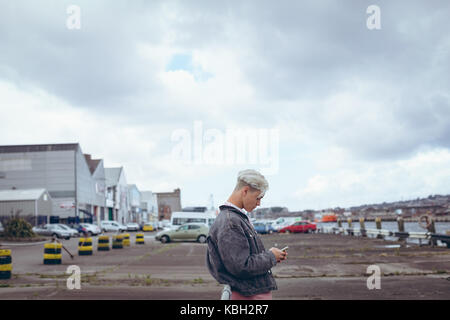 Handsome man using mobile phone near river Stock Photo