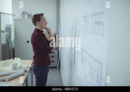 Architect looking at blueprint in studio Stock Photo