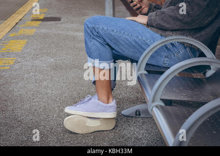 Low section of man using mobile phone at platform Stock Photo