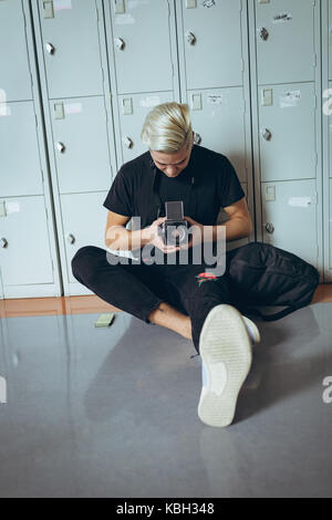 University male student using camera in the corridor of college Stock Photo